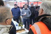 Farmers discuss new measures announced by French Prime Minister Gabriel Attal on a blocked highway, Thursday, Feb.1, 2024 in Argenteuil, north of Paris. France's two major farmers unions announced Thursday their decision to suspend protests and lift road blockades across the country, in a dramatic development shortly after the French prime minister unveiled a new set of measures they see as "tangible progress." Farmers have been protesting for days across the country to denounce low wages, heavy regulation and unfair competition from abroad. (AP Photo/Michel Euler)