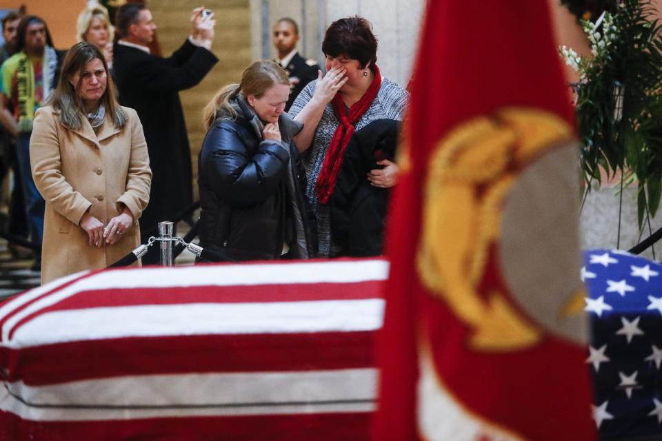Mourners cry as they view the casket of John Glenn, Friday, Dec. 16, 2016, in Columbus, Ohio. Glenn's home state and the nation began saying goodbye to the famed astronaut who died last week at the age of 95. (AP Photo/John Minchillo)