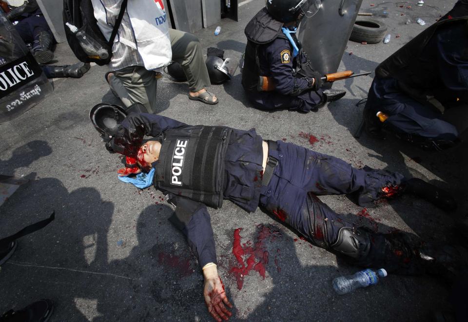 An injured Thai policeman lies near the scene of an explosion during clashes with anti-government protesters near Government House in Bangkok