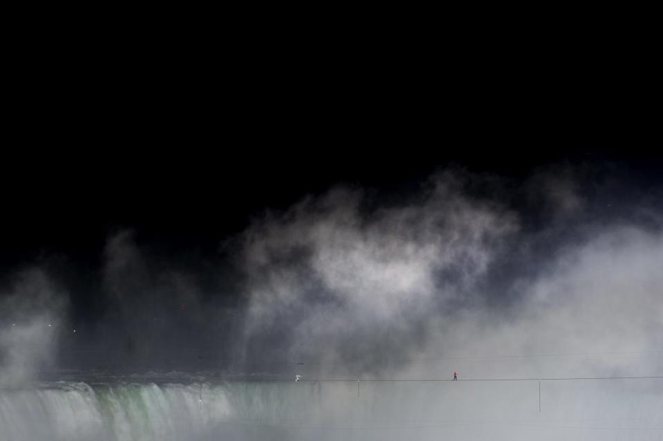 Nik Wallenda walks a tightrope over Niagara Falls as seen from Niagara Falls, Ontario, on Friday, June 15, 2012. Wallenda has finished his attempt to become the first person to walk on a tightrope 1,800 feet across the mist-fogged brink of roaring Niagara Falls. The seventh-generation member of the famed Flying Wallendas had long dreamed of pulling off the stunt, never before attempted. (AP Photo/The Canadian Press, Nathan Denette)