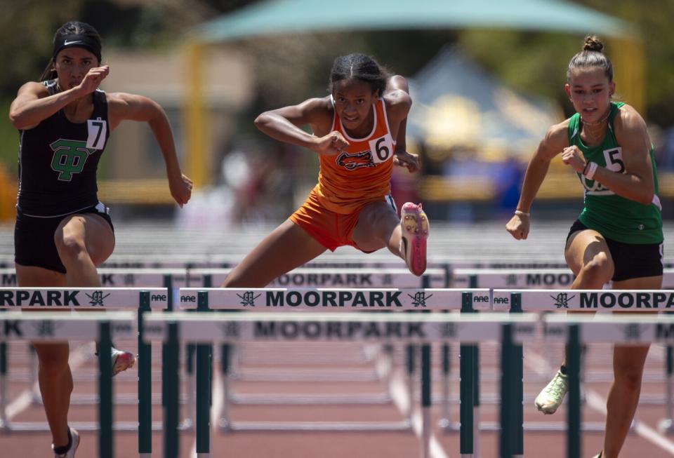 Orange Vista's Kailah McKenzie, center, clears a hurdle.