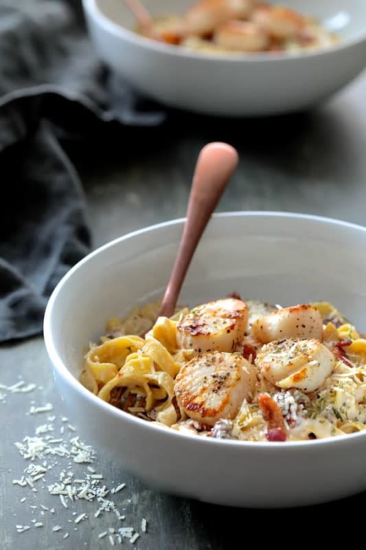 <p>From A Chef's Kitchen</p><p>Serve these succulent, ultra-savory sea scallops over a bed of pasta. And don't forget the glasses of wine.</p><p><strong>Get the recipe: <a href="https://www.fromachefskitchen.com/sea-scallops-bacon-sun-dried-tomato-alfredo-sauce/" rel="nofollow noopener" target="_blank" data-ylk="slk:Seared Sea Scallops with Spicy Bacon and Sun-Dried Tomato Alfredo Sauce;elm:context_link;itc:0;sec:content-canvas" class="link rapid-noclick-resp">Seared Sea Scallops with Spicy Bacon and Sun-Dried Tomato Alfredo Sauce</a></strong></p>