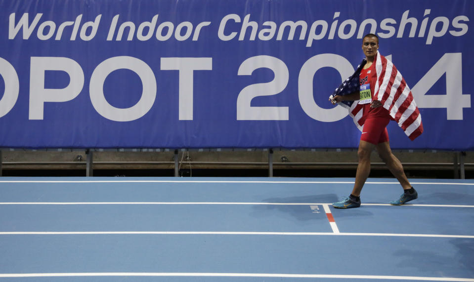 United States' Ashton Eaton celebrates with the American flag after winning the gold of the men's heptathlon during the Athletics Indoor World Championships in Sopot, Poland, Saturday, March 8, 2014. (AP Photo/Matt Dunham)