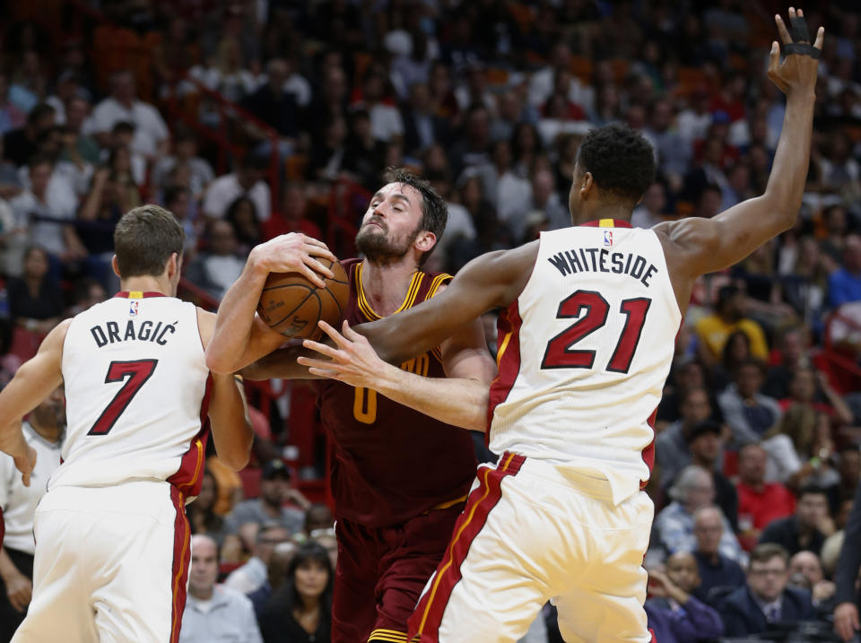File- This April 10, 2017, file photo shows Cleveland Cavaliers forward Kevin Love (0) attempting a shot against Miami Heat center Hassan Whiteside (21) and guard Goran Dragic (7) during the first half of an NBA basketball game, in Miami. The Cavaliers have fallen back on excuses — some legitimate — to explain this disjointed season. Well, those don't matter now. James and the defending champs enter the playoffs staring at a possibly dangerous path. (AP Photo/Wilfredo Lee, File)