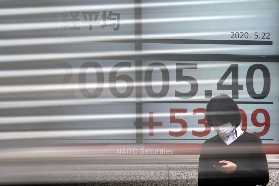 A man stands in front of an electronic stock board showing Japan's Nikkei 225 index as a track goes by at a securities firm in Tokyo Friday, May 22, 2020. Shares are slipping in Asia as tensions flare between the U.S. and China and as more job losses add to the economic fallout from the coronavirus pandemic. (AP Photo/Eugene Hoshiko)