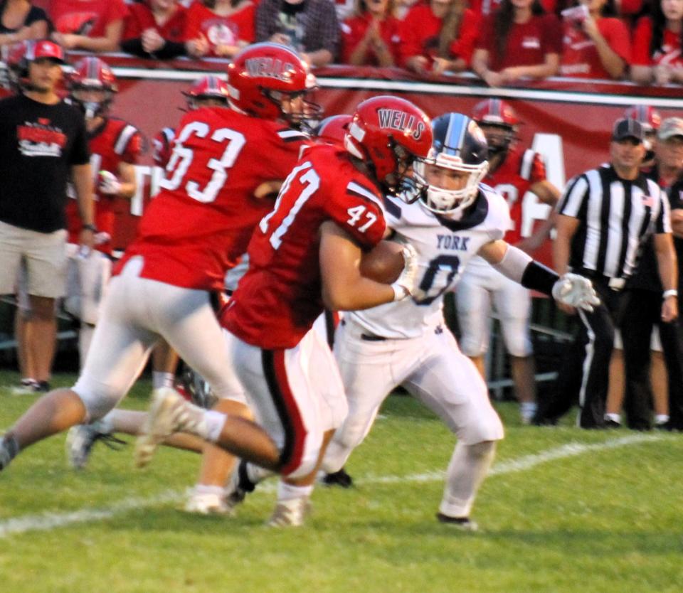 York quarterback Peter Martin (7) gets set to throw a pass as Daniel Rioux (67) helps supply some of the protection during action Saturday night in Wells, Maine.