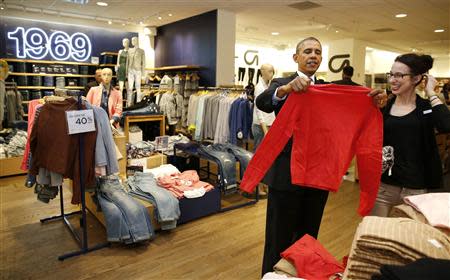 U.S. President Barack Obama looks for gifts for his family with salesperson Susan Panariello after stopping off at the GAP in New York, March 11, 2014. REUTERS/Larry Downing