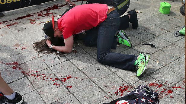 A young man cradles one of the victims of the Boston marathon bombings. Photo: AAP