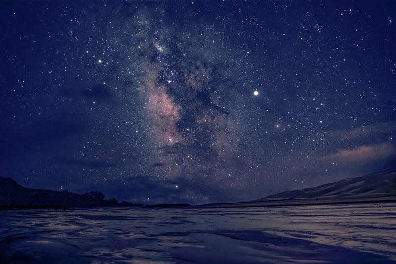The Milky Way and countless stars illuminate Medano Creek at Great Sand Dunes National Park in July 2019.
