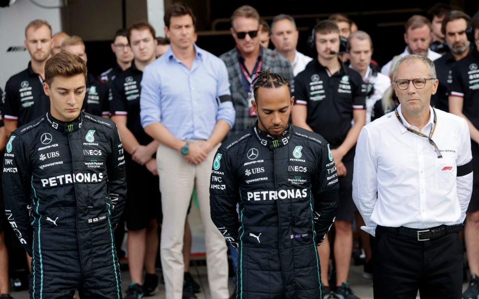 Autodromo Nazionale Monza, Monza, Italy - September 9, 2022 Mercedes' Lewis Hamilto, George Russell and CEO of Formula One Group, Stefano Domenicali are seen during a moments silence after the passing of Britain's Queen Elizabeth before practice - REUTERS