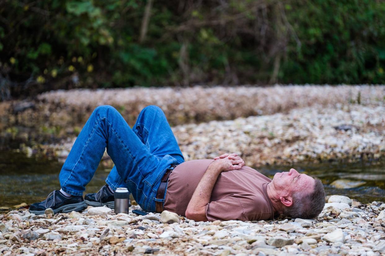 Man, age 65, relaxing on a gravel bar on Sylamore Creek in Arkansas.