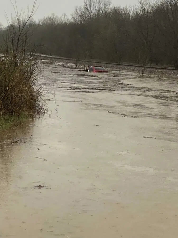 In this photo provided by Layton Hoyer, a red SUV is seen submerged in floodwater on Old Ritchey Road in Granby, Mo., early Friday, March 24, 2023. (Layton Hoyer via AP)