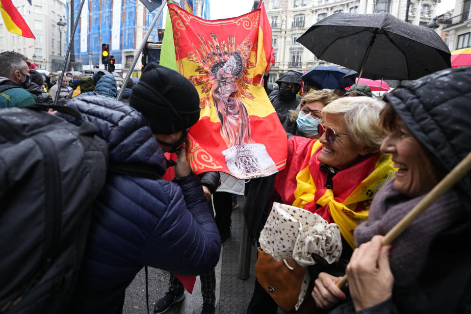 A man kisses a banner with the colors of the Spanish flag and a religious image during a police protest in Madrid, Spain, Saturday, Nov. 27, 2021. Tens of thousands of Spanish police officers and their supporters rallied in Madrid on Saturday to protest against government plans to reform a controversial security law known by critics as the “gag law.” (AP Photo/Paul White)