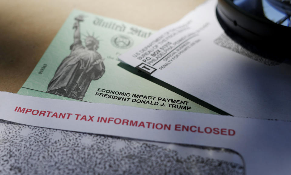 FILE - In this April 23, 2020, file photo, President Donald Trump's name is seen on a stimulus check issued by the IRS to help combat the adverse economic effects of the COVID-19 outbreak, in San Antonio. Hundreds of thousands of dollars in coronavirus relief payments have been sent to people behind bars across the United States, and now the IRS is asking state officials to help claw back the cash that the federal tax agency says was mistakenly sent. (AP Photo/Eric Gay, File)