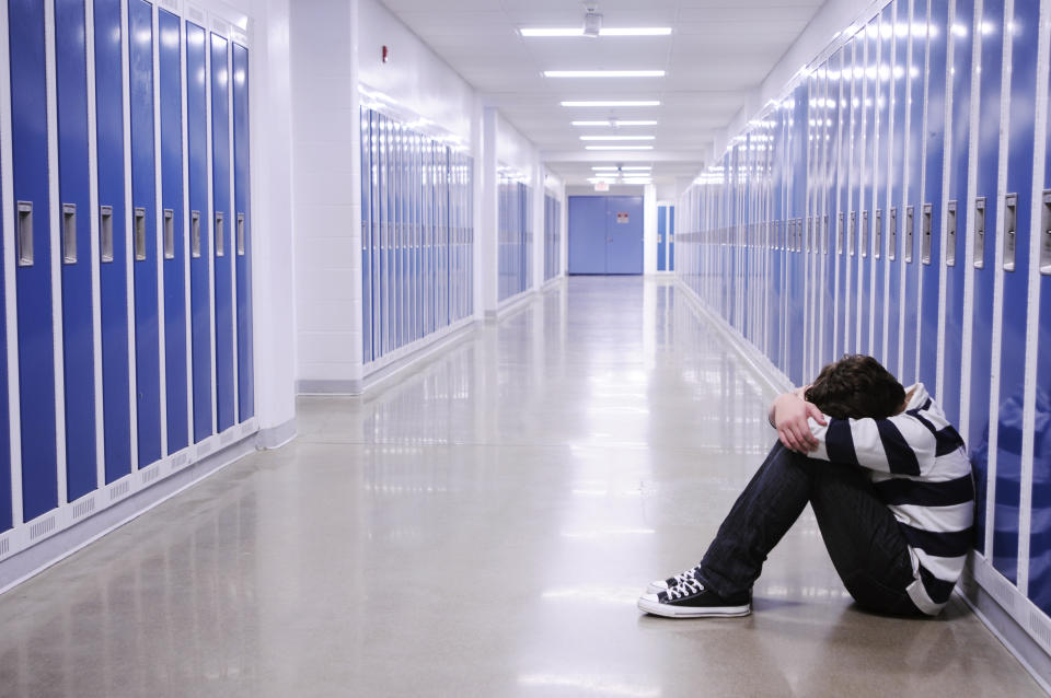 Depressed child in school hallway