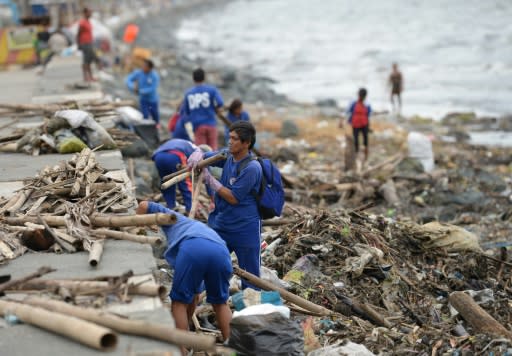 Workers remove debris washed ashore in Manila after Typhoon Yutu made landfall further to the north