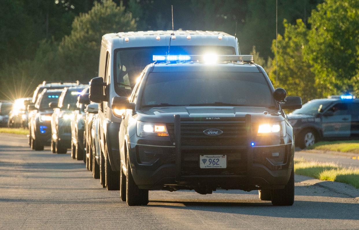 A line of police cruisers, many of them K-9 teams, escorts the body of police dog Frankie from Wachusett Animal Hospital in Westminster Tuesday. Frankie was shot and killed during a standoff with a man in Fitchburg.
