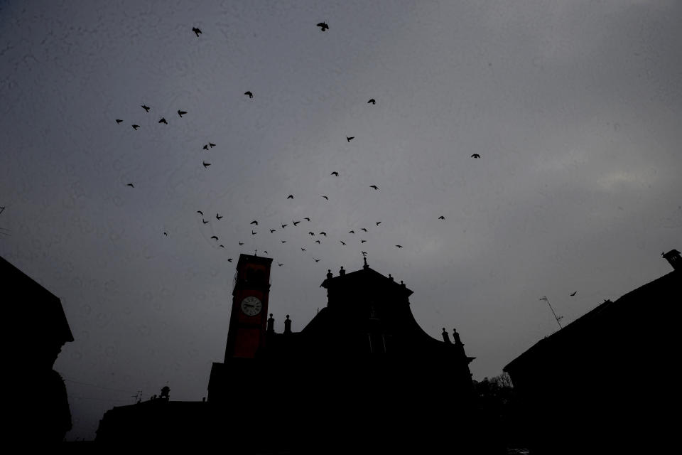 Birds fly over the San Biagio church in Codogno, northern Italy, Sunday, Feb. 21, 2021. Italians are marking one year since their country experienced the first known locally transmitted COVID-19 case in the West. With church services Sunday and wreath-laying ceremonies, including in small northern towns which were the first to be hard-hit by the pandemic, residents paid tribute to the dead. (AP Photo/Luca Bruno)