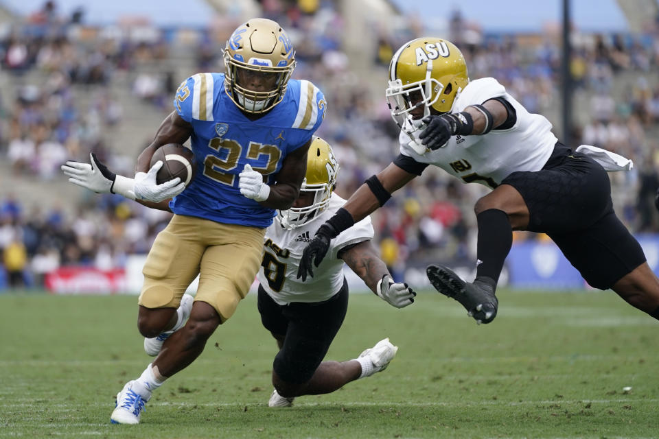 UCLA running back Keegan Jones (22) runs the ball against Alabama State defensive back Irshaad Davis (0) and defensive back Jeffrey Scott Jr. (7) during the first half of an NCAA college football game in Pasadena, Calif., Saturday, Sept. 10, 2022. (AP Photo/Ashley Landis)