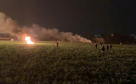 Flames engulf an area as soldiers can be seen moving in. Source: Reuters