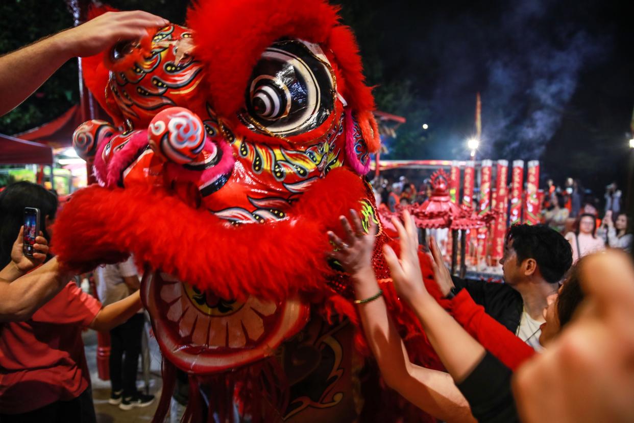 People interact with a lion dance to welcome in the Year of the Dragon during a New Year's Eve celebration at Sze Yup Kwan Ti temple on Lunar New Year's Eve on February 09, 2024 in Sydney, Australia.