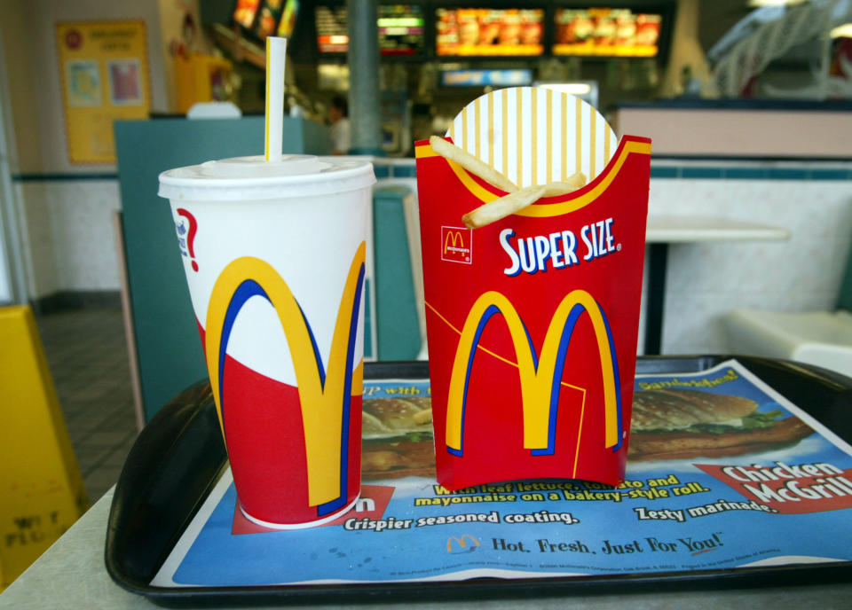 super size fries and drinks on a tray