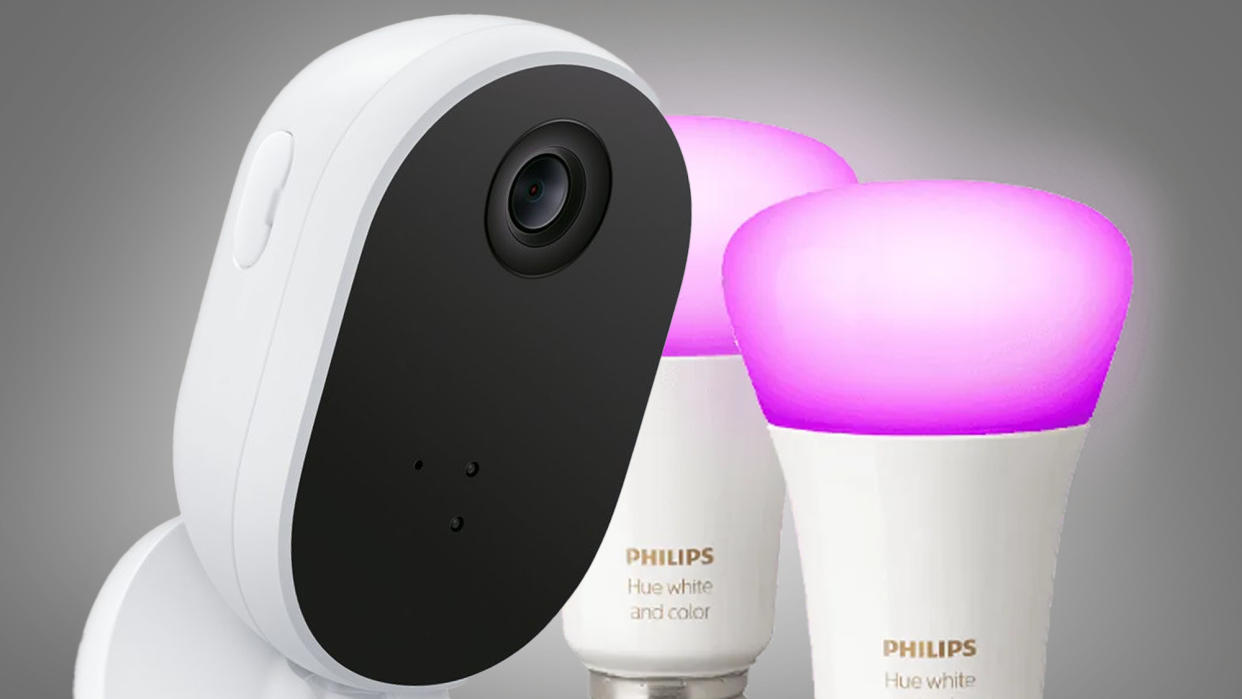  The WiZ Indoor security camera next to two Philips Hue lightbulbs on a grey background 