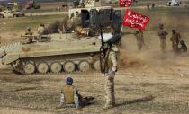 Shi'ite fighters sit in front of a tank during deployments in the town of Hamrin in Salahuddin province March 3, 2015. REUTERS/Thaier Al-Sudani