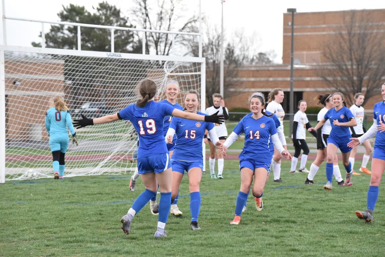 Lenawee Christian's Olivia Durbin (19) runs toward Kylie Summer (15), Natalie Morr (14) and Callie Anderson after a goal during Thursday's game against Manchester.