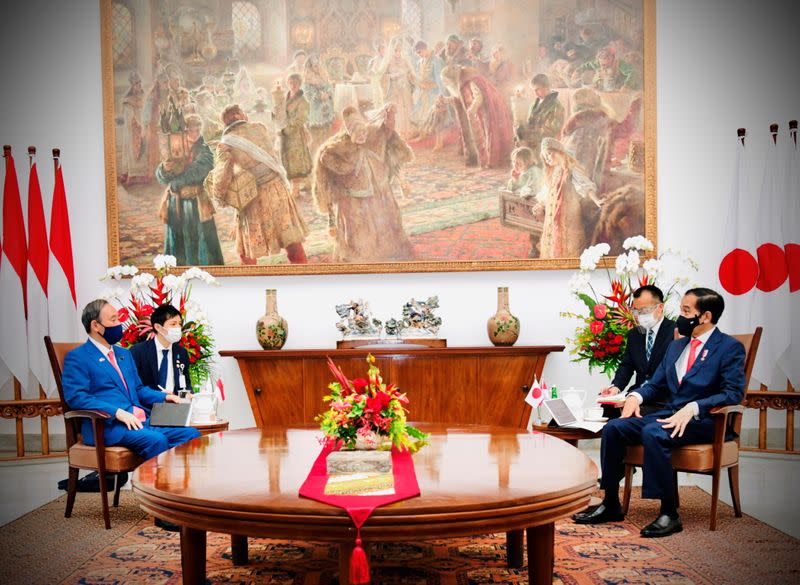 Japan's Prime Minister Suga talks with Indonesian President Widodo during his visit at the Indonesian Presidential Palace in Bogor