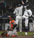 Baltimore Orioles catcher Pedro Severino kneels by the plate as Seattle Mariners' Tom Murphy (2) is greeted by Taylor Trammell, right, after Murphy hit a solo home run in the fifth inning of a baseball game, Monday, May 3, 2021, in Seattle. (AP Photo/Ted S. Warren)