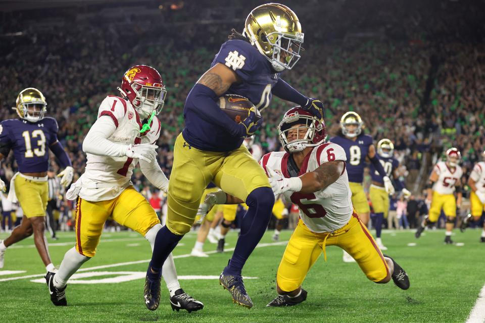 SOUTH BEND, INDIANA - OCTOBER 14: Xavier Watts #0 of the Notre Dame Fighting Irish stiffs arms Austin Jones #6 of the USC Trojans after intercepting a pass from Caleb Williams #13 (not pictured) during the first half at Notre Dame Stadium on October 14, 2023 in South Bend, Indiana. (Photo by Michael Reaves/Getty Images)