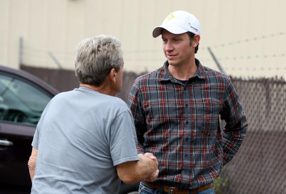 Logan Rohr, right, a Wooster area livestock farmer and owner of Dalton-based 3D Meats, was the high bidder Monday for the Discount Outlet building and a neighboring parcel. Rohr's winning bid for both properties came in at $715,000 after fees.