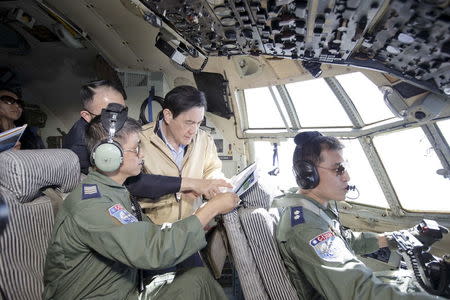 Taiwan's President Ma Ying-jeou (C) reads a document on a C-130 airplane on the way to the disputed Itu Aba or Taiping island in the South China Sea, January 28, 2016. REUTERS/Chen Chien Hsing/Presidential Office/HandoutA