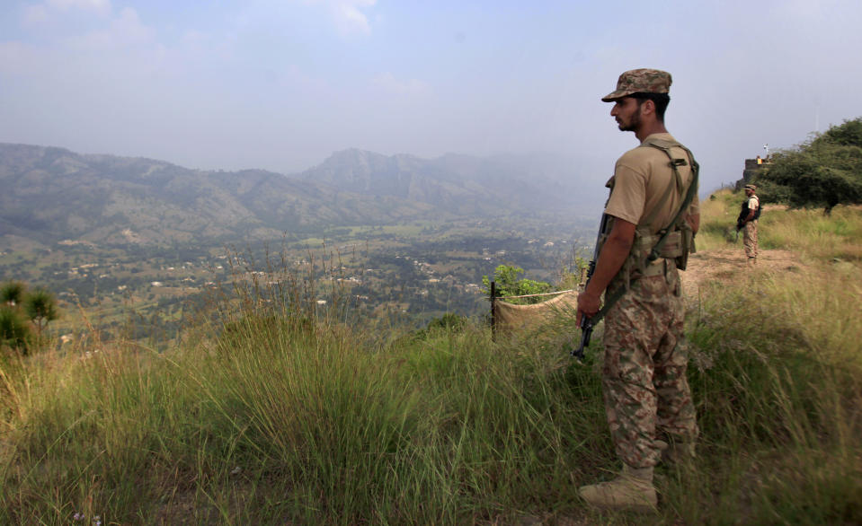 FILE- In this Oct. 1, 2016, file photo, Pakistan army soldiers monitor the area from the hilltop Bagsar post on the line of control, that divides Kashmir between Pakistan and India, near Bhimber, some 166 kilometers (103 miles) from Islamabad, Pakistan. The highly militarized de facto border that divides the disputed region between the two nuclear-armed rivals India and Pakistan, and a site of hundreds of deaths, is unusually quiet after the two South Asian neighbors agreed in February, 2021, to reaffirm their 2003 cease-fire accord. (AP Photo/Anjum Naveed, File)