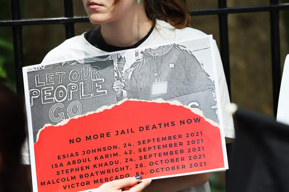 A demonstrator holds a sign saying: Let Our People Go, No More Jail Deaths Now and the names, ages and dates of death of deceased inmates, starting with Esias Johnson, 24, September 2021.  