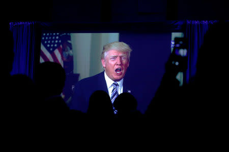 Guests watch a video of U.S. President Donald Trump as he addresses the 15th Plenary Assembly of the World Jewish Congress in New York City, U.S., April 23, 2017. REUTERS/Brendan McDermid