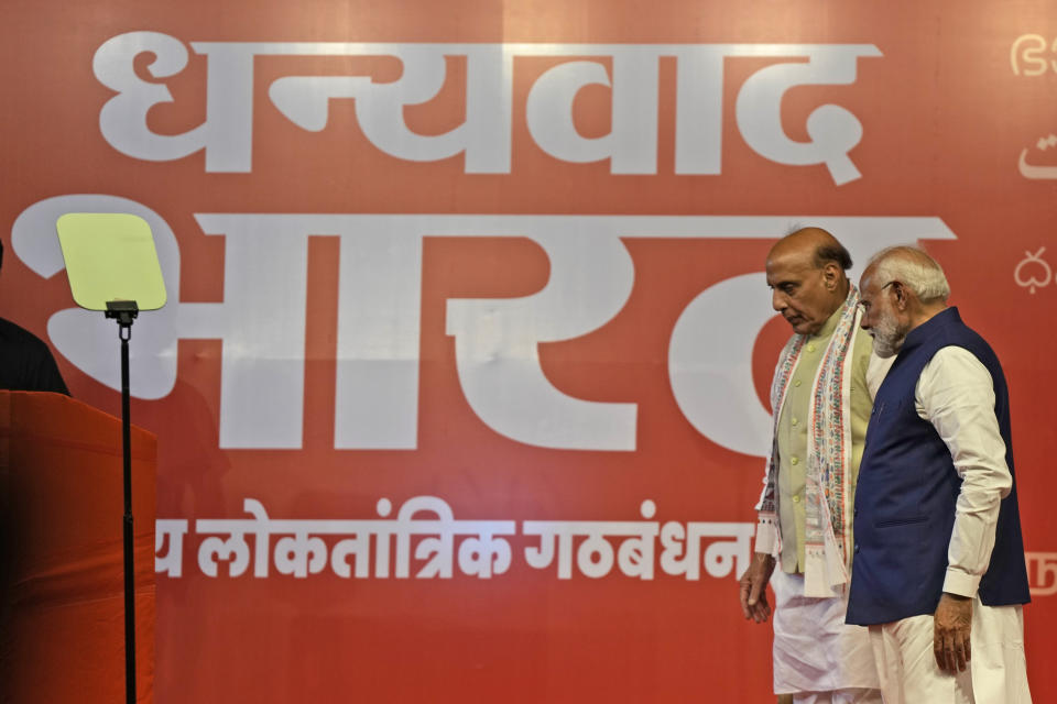 Prime Minister Narendra Modi, right, with Defense Minister Rajnath Singh leaves after addressing supporters at the Bharatiya Janata Party (BJP) headquarters, in New Delhi, India, Tuesday, June 4, 2024. On the banner it's written in local language 'Thank you Bharat". (AP Photo/Manish Swarup)