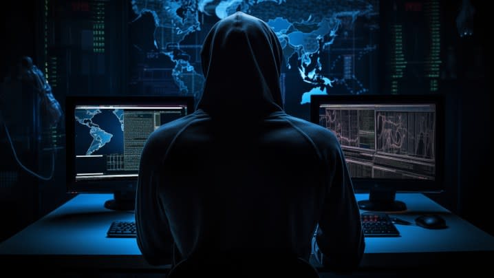 A concept image of a hacker at work in a dark room.