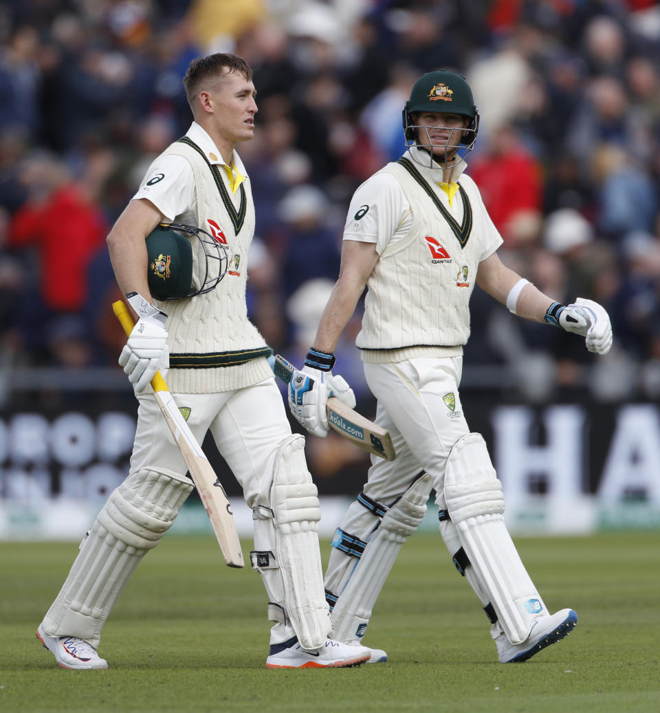 Australia's Steven Smith, right, and Marnus Labuschagne return to the pavilion for lunch break during day one of the fourth Ashes Test cricket match between England and Australia at Old Trafford in Manchester, England, Wednesday, Sept. 4, 2019. (AP Photo/Rui Vieira)