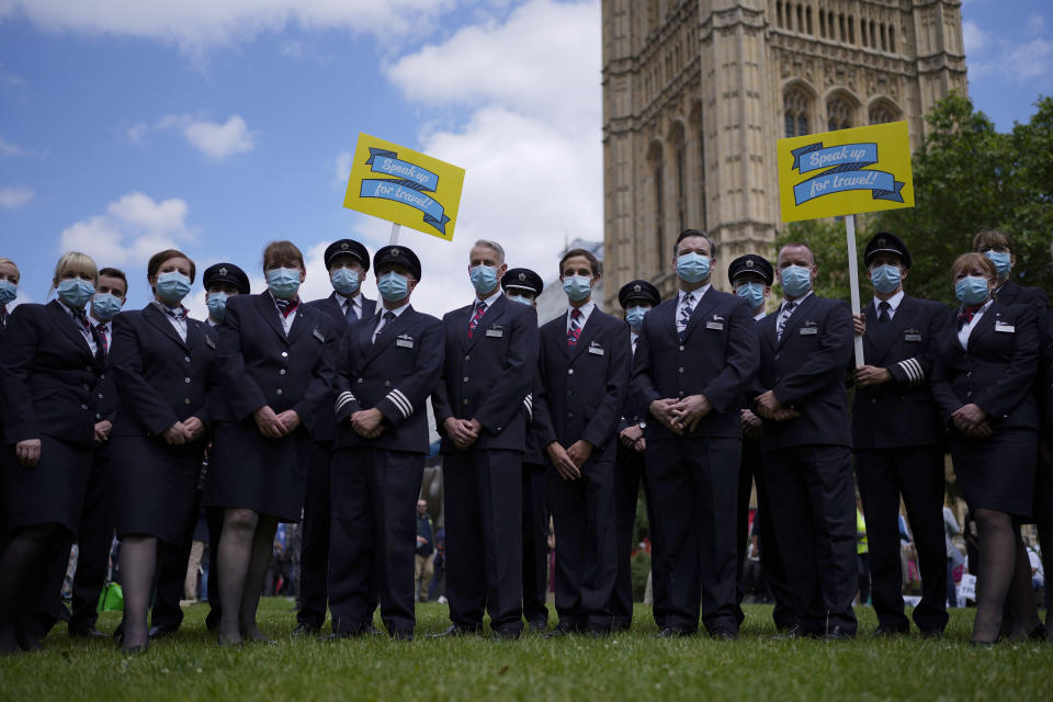 British Airways flight and cabin crew pose for photographers as they take part in a 'Travel Day of Action' protest across the street from the Houses of Parliament in London, Wednesday, June 23, 2021. The protest on Wednesday was attended by people from across the UK aviation and travel industry calling on the British government to safely reopen international travel for the peak summer season to protect travel jobs and businesses amidst Britain's widely praised rollout of coronavirus vaccines. (AP Photo/Matt Dunham)