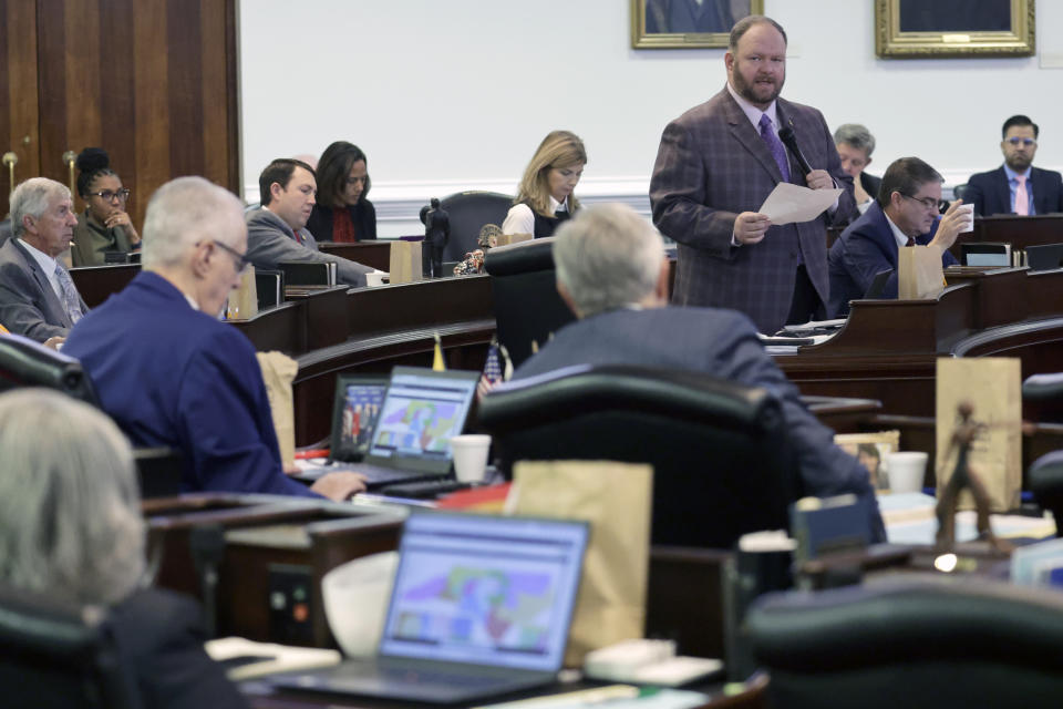 While other senators look at the map on their computers, Sen. Ralph Hise (R-Mitchell), top right, one of the sponsors of a congressional redistricting bill, speaks as the North Carolina Senate debates the bill at the Legislative Building, Tuesday, Oct. 24, 2023, in Raleigh, N.C. (AP Photo/Chris Seward)