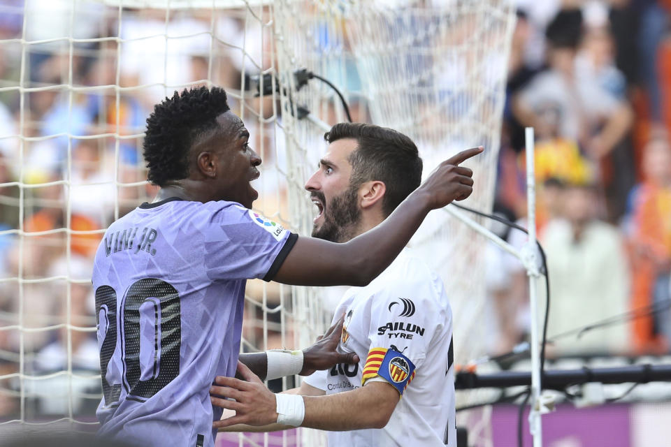 Real Madrid's Vinicius Junior, left, confronts Valencia fans in front of Valencia's Jose Luis Gaya during a Spanish La Liga soccer match between Valencia and Real Madrid, at the Mestalla stadium in Valencia, Spain, Sunday, May 21, 2023. The game was temporarily stopped when Vinicius said a fan had insulted him from the stands. He was later sent off after clashing with Valencia players. (AP Photo/Alberto Saiz)