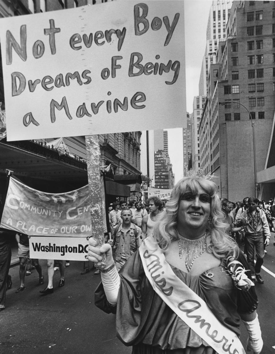 A gay rights protester in drag with a banner declaring 'Not Every Boy Dreans Of Being A Marine' during a gay rights march up Fifth Avenue to Central Park, New York City.
