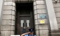 A security guard salutes in front of the Bank of Japan (BOJ) building in Tokyo, Japan, July 29, 2016. REUTERS/Kim Kyung-Hoon