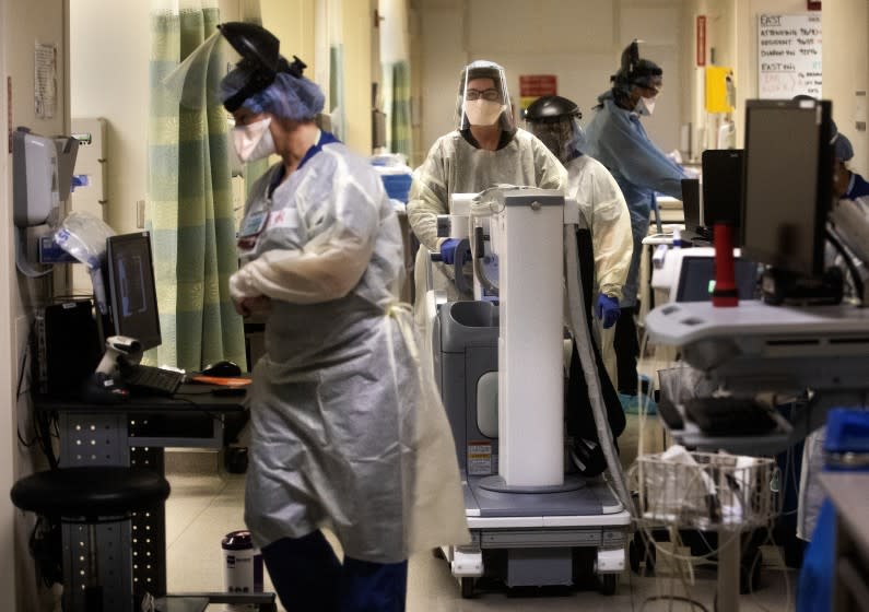 LOS ANGELES, CA-APRIL 23, 2020: Medical staff, wearing protective gear, work inside a Covid 19 isolation area, inside the emergency department at Los Angeles County+USC Medical Center in Los Angeles, where patients with the virus are being treated. (Mel Melcon/Los Angeles Times)