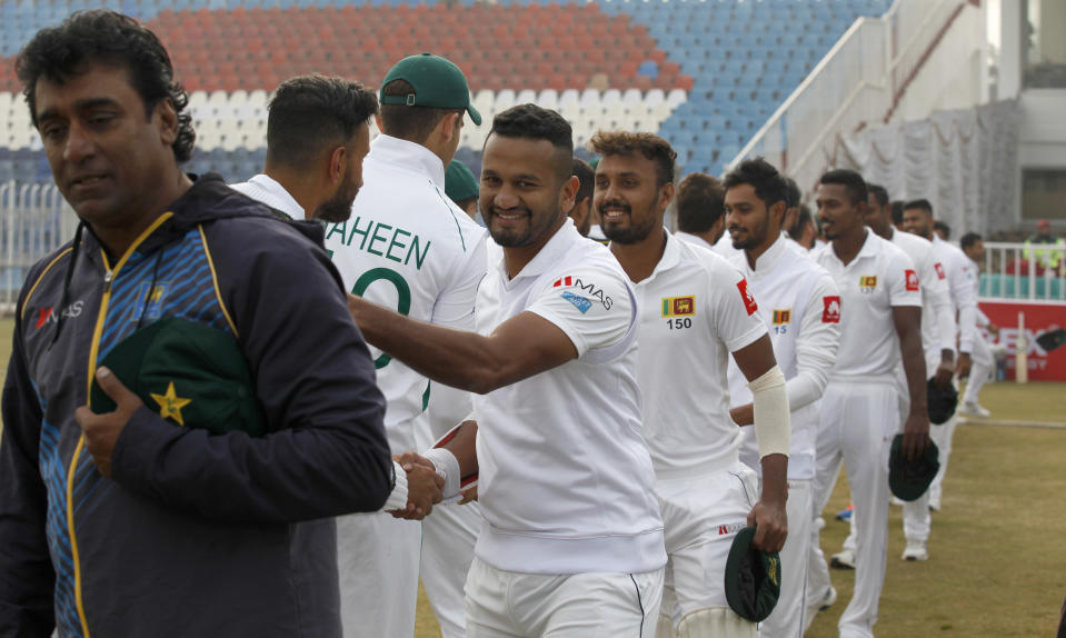 Sri Lankan and Pakistani players shake hands after exchanging caps ahead of the first cricket test match between Pakistan and Sri Lanka, in Rawalpindi, Pakistan, Wednesday, Dec. 11, 2019. (AP Photo/Anjum Naveed)
