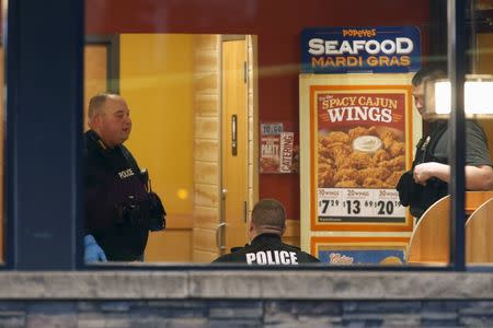 Police officers search for evidence in the shooting death of a Prince George's County Police officer at a Popeye's chicken restaurant near the primary crime scene where the officer was shot in Landover, Maryland March 13, 2016. REUTERS/Jonathan Ernst