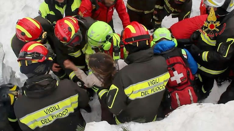 A woman is rescued from the snowbound Hotel Rigopiano, near the village of Farindola in central Italy on January 20, 2017, after it was struck by an avalanche