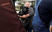 <p>A woman carries her dog into a collector’s vintage military truck to evacuate from flood waters from Hurricane Harvey in Dickinson, Texas Aug. 27, 2017. (Photo: Rick Wilking/Reuters) </p>